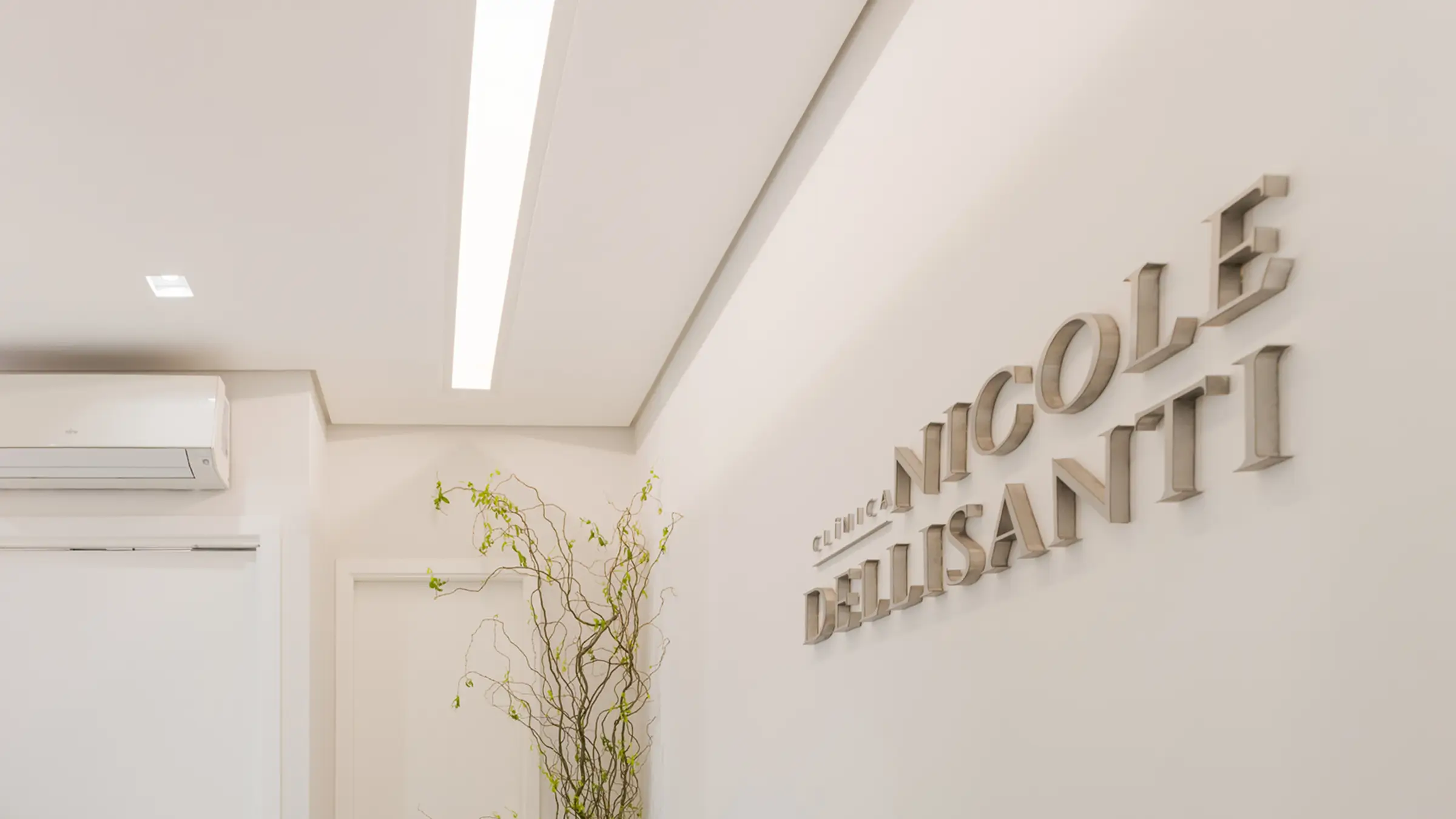 Recepcao da Clinica Nicole Dellisanti com o logotipo em relevo na parede