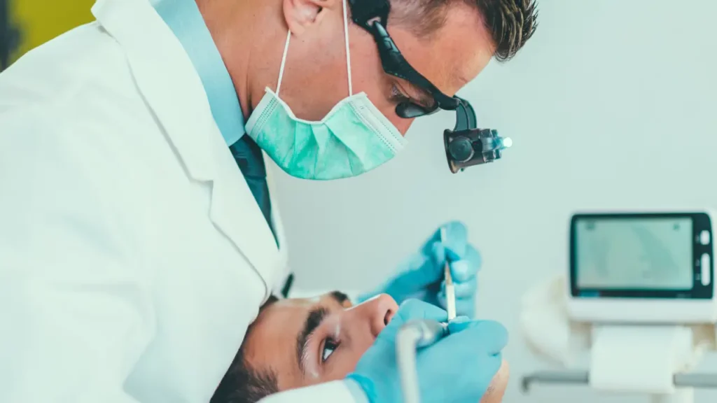 dentista olhando a boca de um paciente